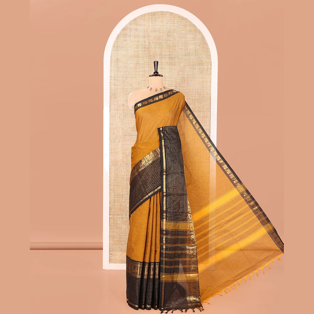 Pothys Mustard Plain Chettinad Cotton Saree, Complemented by a Contrast Zari Traditional Border Steeped with Peacock Designs, Subtly Striped Pallu, and Paired with a Matching Blouse