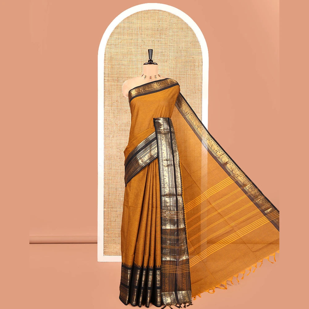 Pothys Mustard Plain Chettinad Cotton Saree, Complemented by a Contrast Rettai Pettu Temple Sliver-Sheen-Gold Zari Border of Coin, Elephant, and Peacock Designs, Subtly Striped Pallu, and Paired with a Matching Blouse